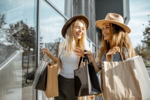 Two,Happy,Girlfriends,Looking,On,The,Shopwindow,While,Standing,With